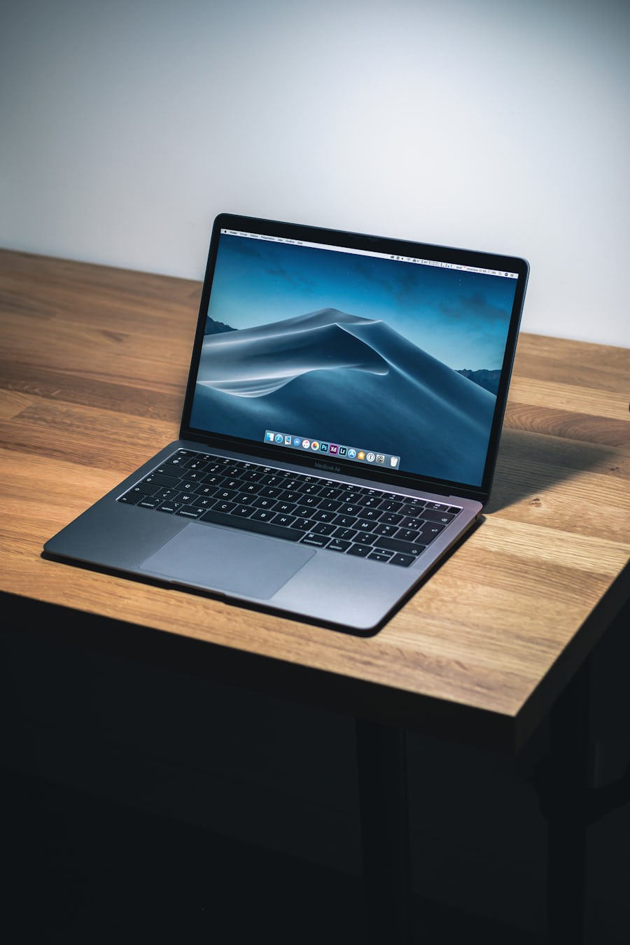 Laptop terbuka di meja kayu sebagai ilustrasi memulai panduan permainan online