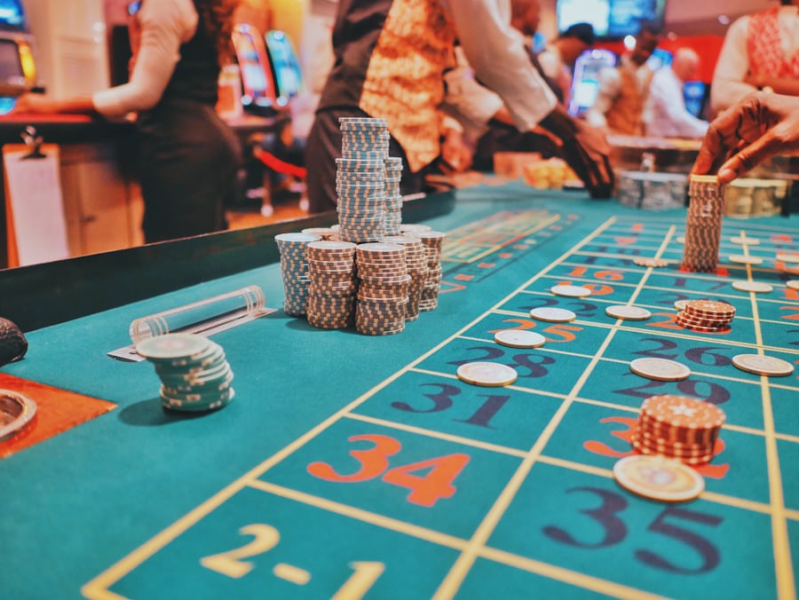 Meja kasino dengan tumpukan chip poker sebagai ilustrasi kategori poker online